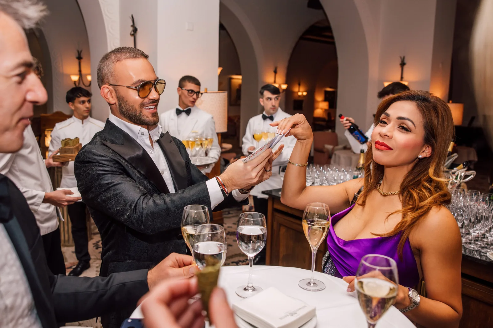 A guest reacting to Matteo Cammisa's close-up magic at the bar during an evening at Suvretta House, St. Moritz