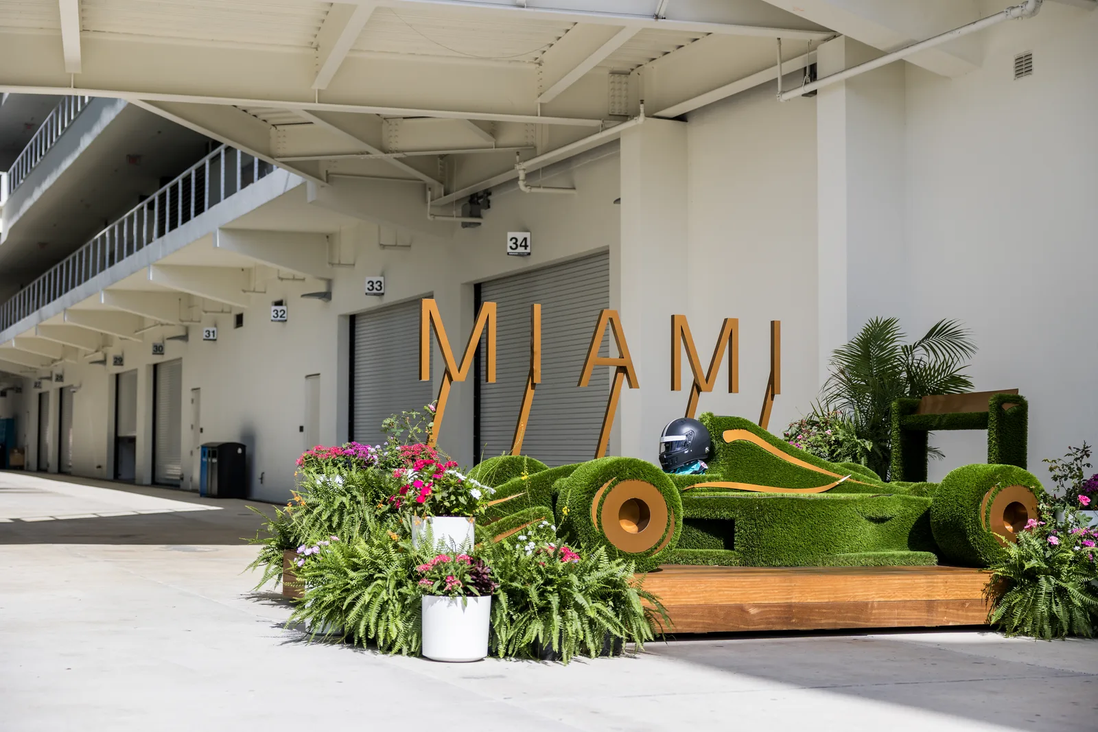 The MIAMI letters and a topiary Formula 1 car display inside the Miami International Autodrome paddock