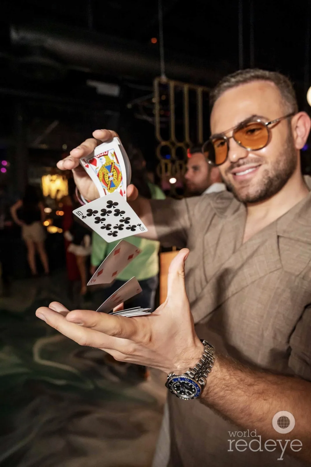 Matteo Cammisa producing a fan of cards in mid-air at the grand opening of Sora in Wynwood, Miami