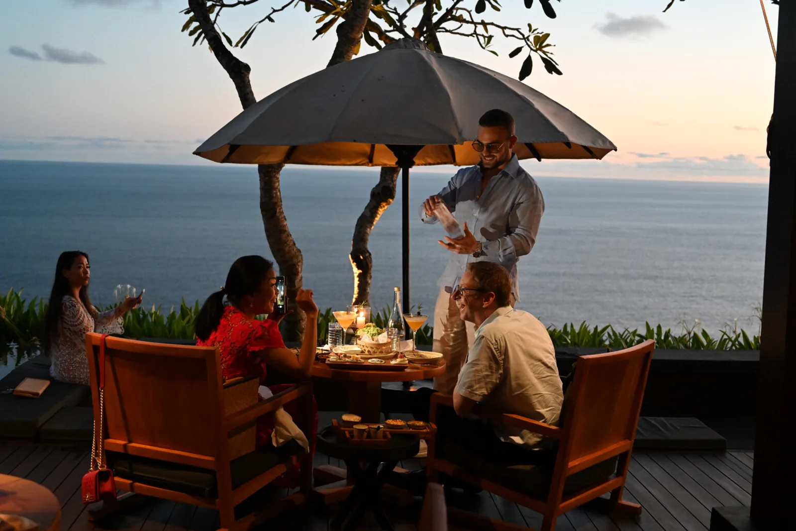 Matteo Cammisa performing close-up magic at a sunset dinner on the clifftop terrace of BVLGARI Resort Bali